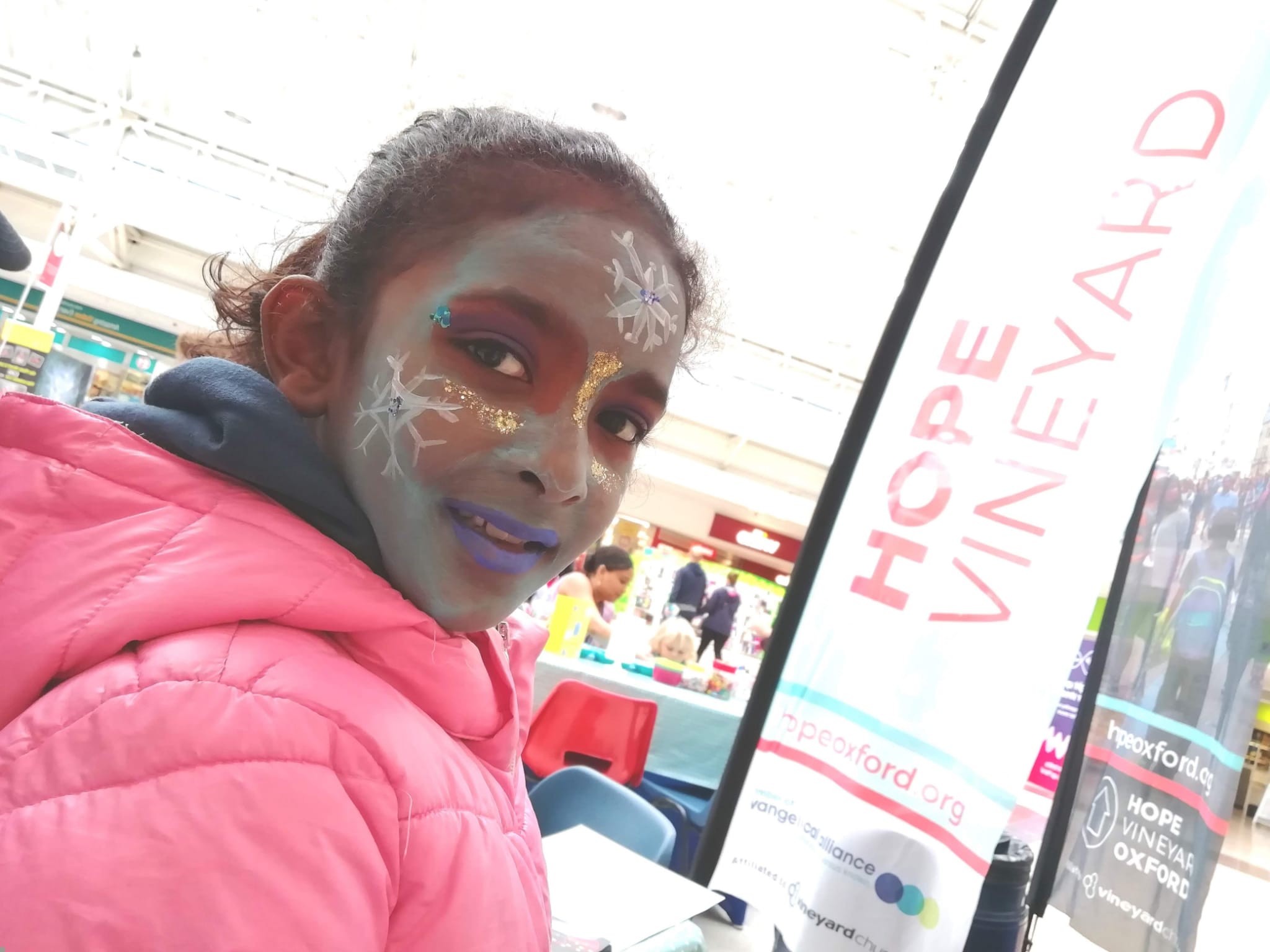 Hope Vineyard sign next to girl with face painted