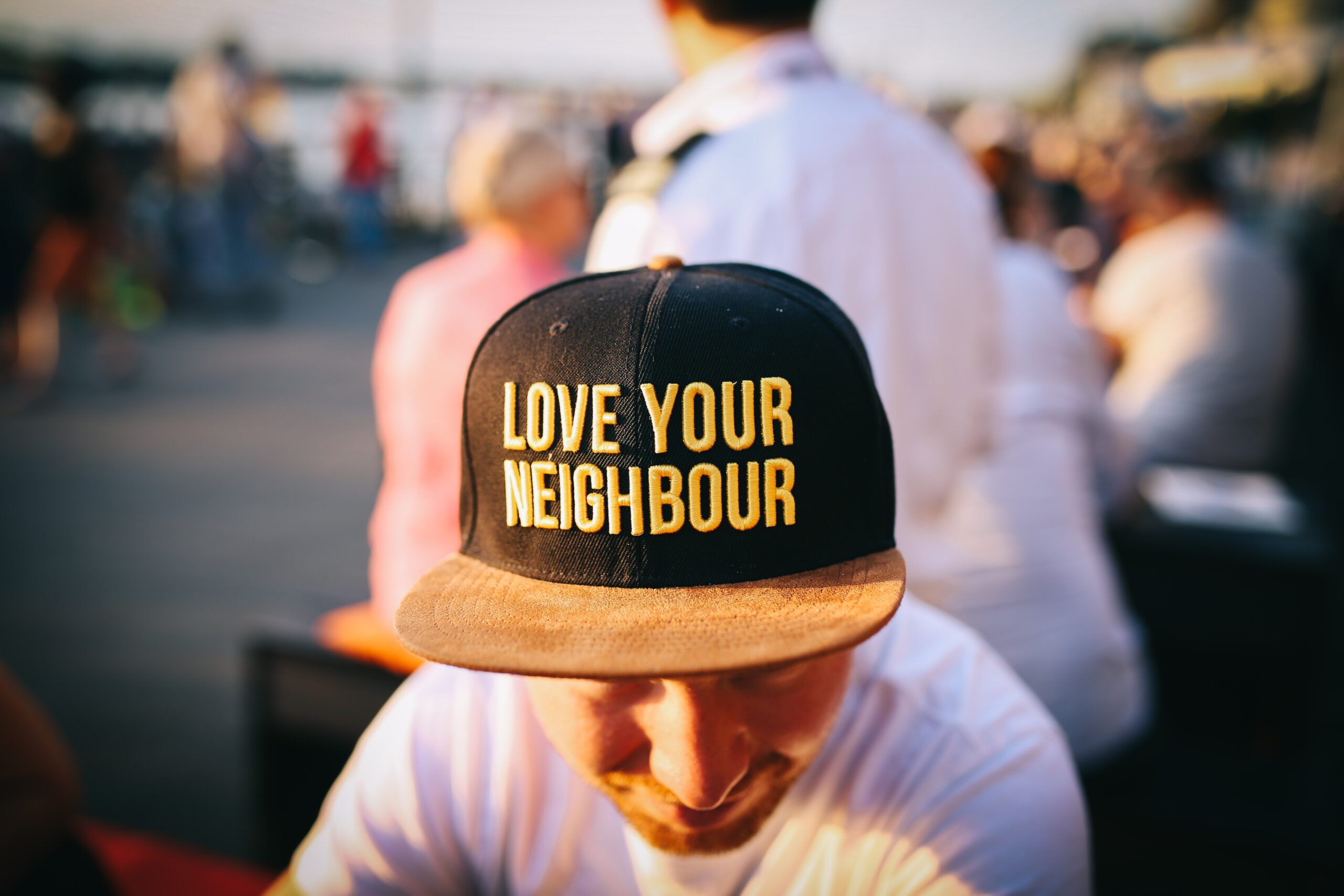 Love Your Neighbour cap being worn by a man