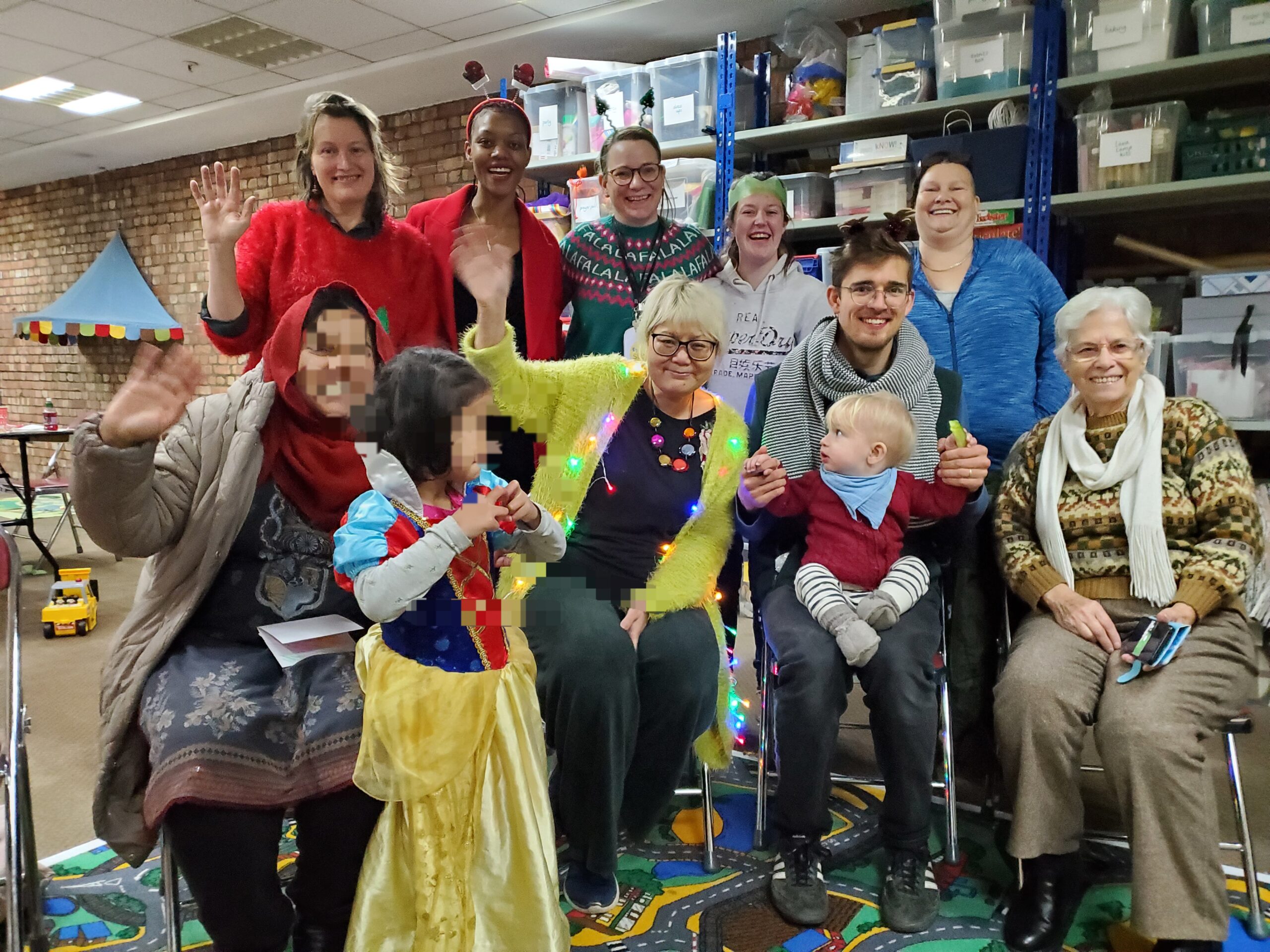 Group saving and smiling at camera, mixed ages